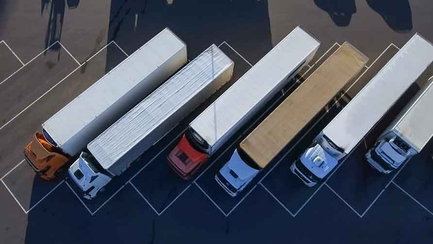 Dette billede viser lastvogne der er parkeret på en parkeringsplads.